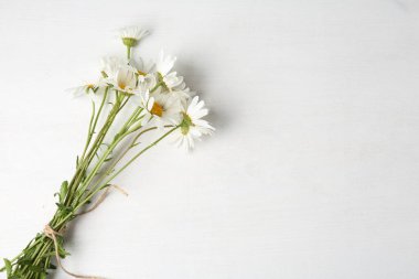 Beyaz ahşap masada bir demet güzel papatya çiçeği, düz bir şekilde yatıyordu. Metin için boşluk