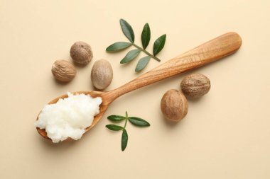 Tereyağı, fındık ve yapraklar bej arka planda, düz uzandı