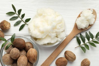 Doğal Shea yağı, fındık ve yapraklar beyaz ahşap masa, düz yatıyordu