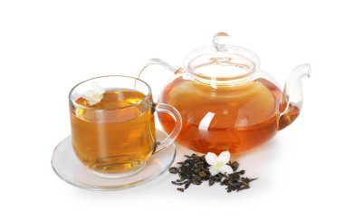 Aromatik yasemin çayı, cam bardak, çaydanlık, çiçekler ve kuru yapraklar beyaz üzerine izole edilmiş.