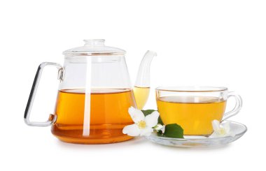 Aromatik yasemin çayı cam bardakta, çaydanlık ve çiçekler beyazda izole edilmiş.