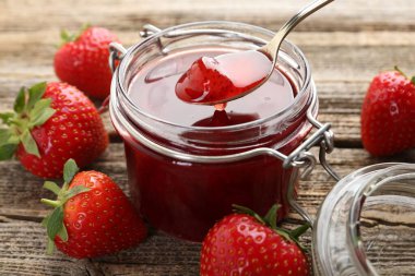 Tahta masada kaşıkla lezzetli çilek reçeli alıp yakın plan çekiyoruz.