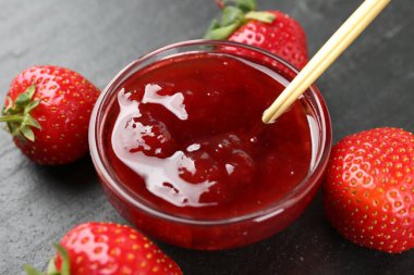 Lezzetli ev yapımı çilek reçeli ve siyah masada böğürtlen, yakın plan.