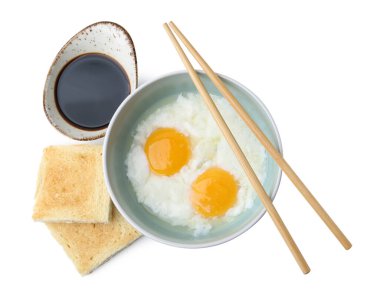 Kavanozda yarı haşlanmış yumurta, soya sosu, kızarmış ekmek ve beyaza izole edilmiş çubuklar, üst manzara. Geleneksel Asya kahvaltısı