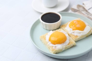 Lezzetli kaya tostları, yarım haşlanmış yumurtalarla beyaz fayanslı masada servis edilir, yakın plan. Geleneksel Asya kahvaltısı