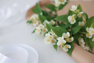 Yasemin dalları ve kraft kağıtları beyaz masada, yakın plan. Metin için boşluk