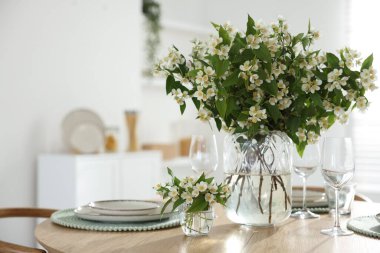 İçerideki yemek masasında bir buket güzel yasemin çiçeği. Metin için boşluk