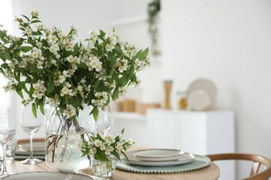 İçerideki yemek masasında bir buket güzel yasemin çiçeği. Metin için boşluk