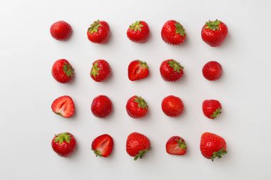 Beyaz arka planda taze olgun çilekler, düz uzanmış.