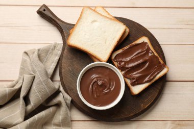 Lezzetli çikolatalı tereyağı ve ekmek dilimleri açık ahşap masa, üst manzara.