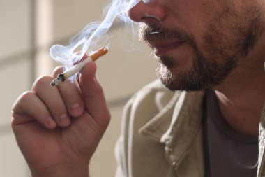 Arka planda sigara içen adam, yakın plan.