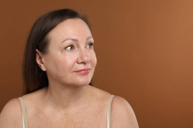 Kahverengi arka planda estetik ameliyattan önceki kadın. Metin için boşluk