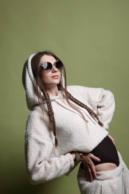 Yeşil arka planda şık giyinmiş güzel bir kadının moda portresi.