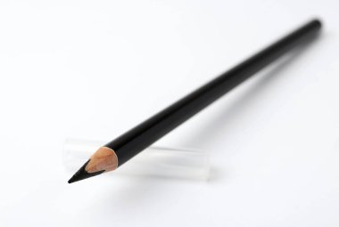 Beyaz arka planda siyah kaş kalemi, yakın plan. Metin için boşluk