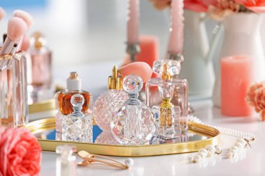 İçerideki tuvalet masasında farklı parfüm ve aksesuar şişeleri, yakın plan.