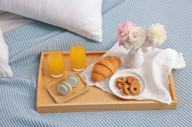 Nefis bir kahvaltı tepsisi ve çiçeklerle kapalı bir yerde, yakın plan.