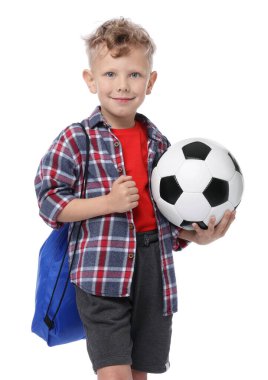 Beyaz arka planda futbol topu ve spor çantası olan küçük bir çocuk.