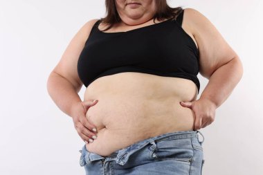 Beyaz arka planda aşırı göbek yağı olan kadın, yakın plan.