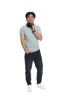 Beyaz arka planda kulaklık takan yakışıklı Asyalı adam.