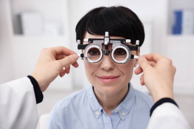 Hastanın vizyonunu klinikte deneme çerçevesiyle inceleyen oftalmolog, yakın plan.