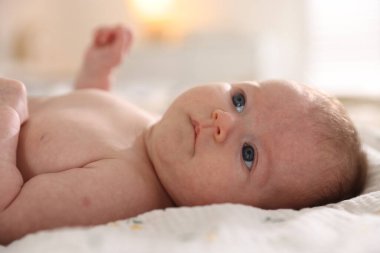 Sevimli yeni doğmuş bebek yatakta uzanıyor, yakın plan.