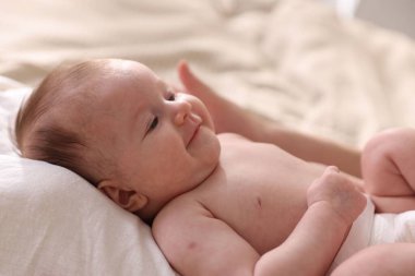 Anne yeni doğmuş bebeğini evde yatağına yatırıyor.