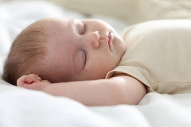 Yeni doğmuş şirin bebek evde yatakta uyuyor.