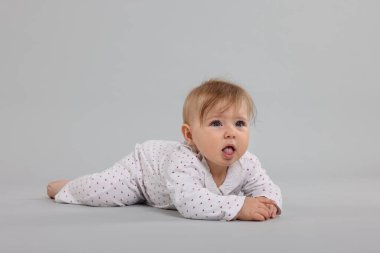 Açık gri arka planda şirin bir bebek.