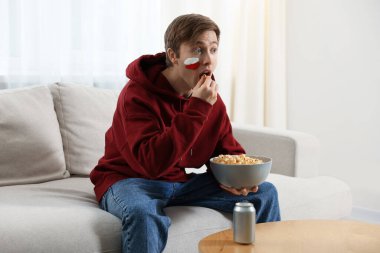 Spor fanatiği içeride maç izlerken patlamış mısır yiyor