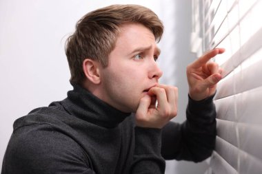 Paranoya işte. Endişeli adam pencereden içeri bakıyor.