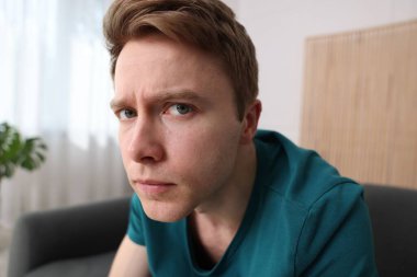 Evde paranoyadan muzdarip korkmuş bir adam.