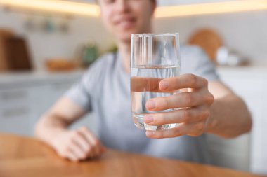 Mutfakta bir bardak suyu olan adam, seçici odaklanma