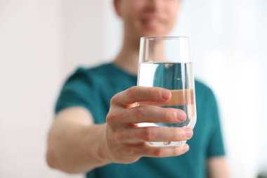 Evinde bir bardak su olan adam, seçici odaklı.