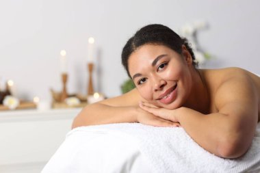 Güzel bir kadın masaj salonundaki masaj koltuğunda dinleniyor, mesaj atmak için yer var.