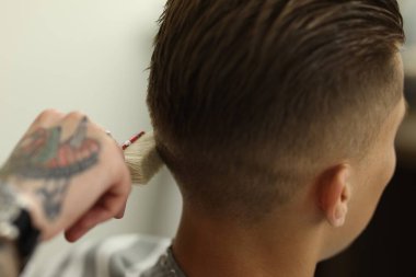 Berber dükkanında müşteriyle çalışan profesyonel berber, yakın plan.