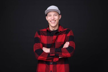 Siyah arka planda şık bir beyzbol şapkası giyen genç adam.