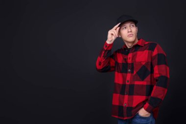 Siyah arka planda şık bir beyzbol şapkası giyen genç adam, mesaj için yer var.