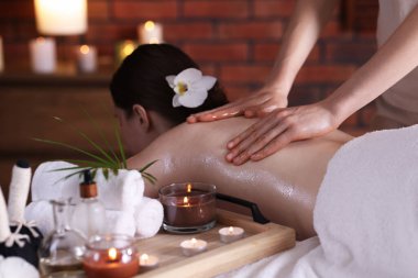 Spa salonunda kadın sırt masajı yaptırıyor.