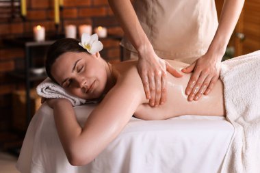 Spa salonunda kadın sırt masajı yaptırıyor.