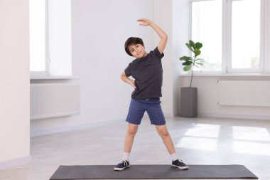 Yoga paspası üzerinde egzersiz yapan tatlı çocuk.