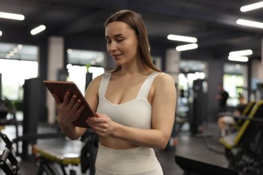 Spor merkezinde tableti olan kişisel antrenör.