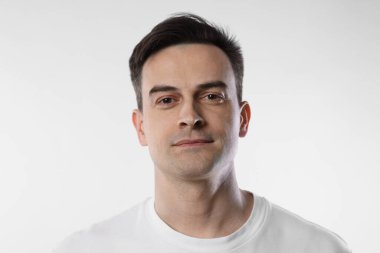 Hafif arka planda yakışıklı bir adamın portresi, yakın plan.