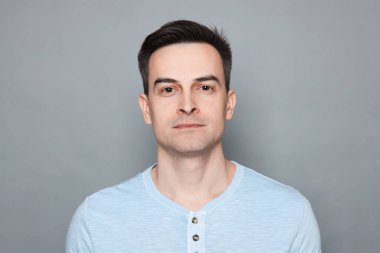 Gri arka planda tıraş olduktan sonra insan portresi