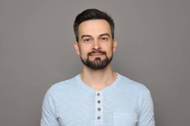 Gri arka planda tıraş olmadan önce yakışıklı bir adam.