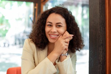 Kafedeki gülümseyen Latin Amerikalı kadının portresi.