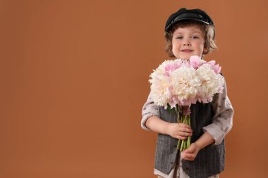 Kahverengi arka planda şakayık demeti olan şirin bir çocuk. Metin için boşluk