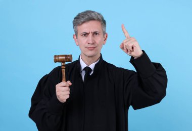 Açık mavi arka planda tokmağı olan duygusal yargıç.