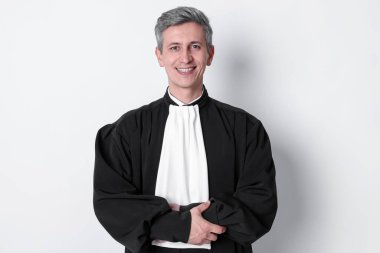 Hafif arka planda mahkeme elbisesi içinde gülümseyen yargıç