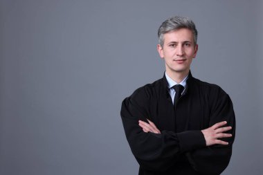 Gri arka planda mahkeme elbisesi giyen yargıç. Metin için boşluk