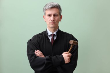 Yeşil arka planda çekiçli yargıç portresi